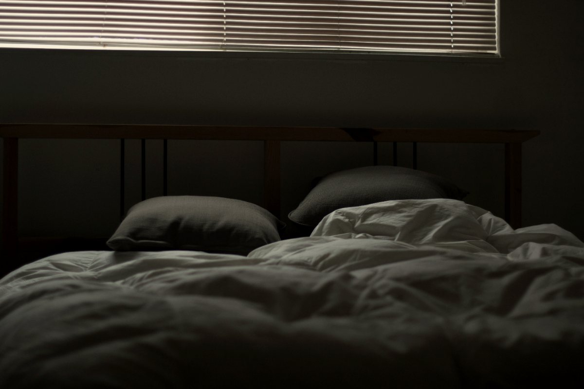 Dim bedroom with light through blinds