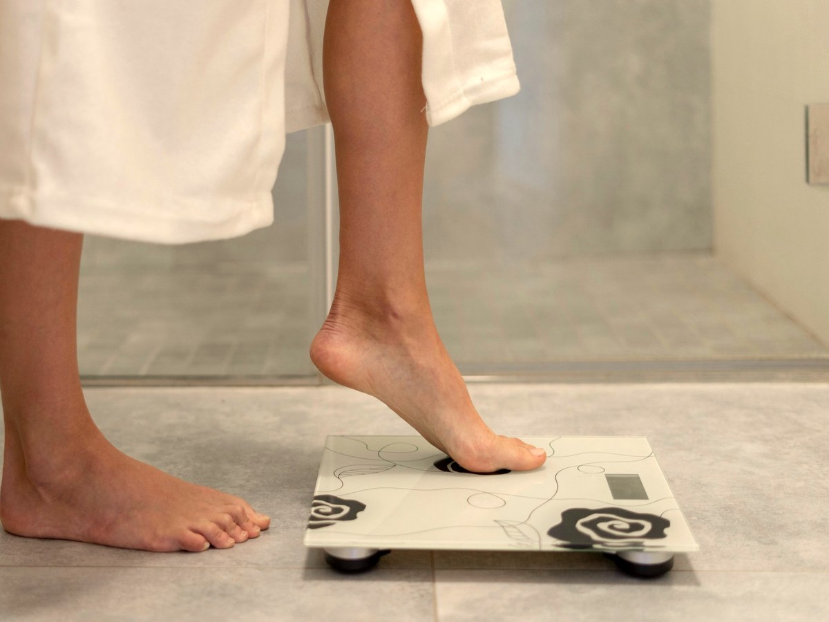 Bare foot stepping onto a bathroom scale